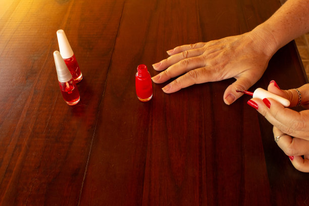 女性的手在给自己涂指甲。图片下载