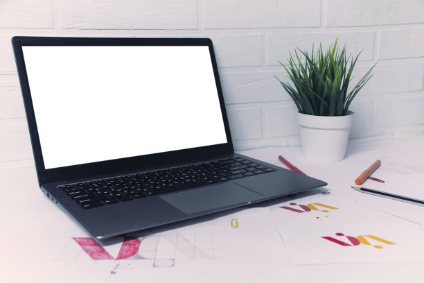 创意工作场所的一个图形设计师与原型笔记本电脑。为公司开发一个标志。在美术工作室办公室的纸上画素描。图片下载