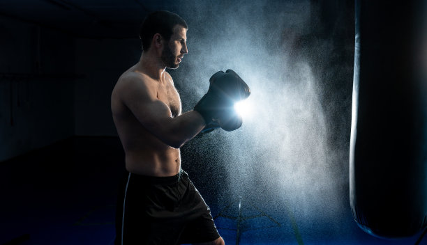 强大的男性拳击手与沙袋为上勾拳训练图片下载