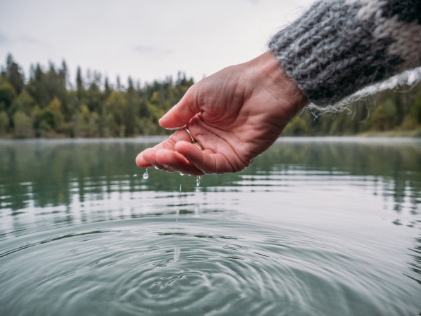 手从高山湖舀水图片下载