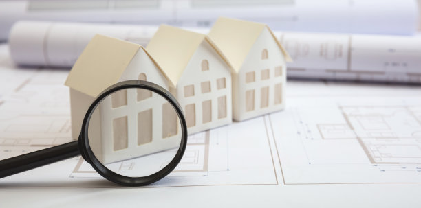 建筑的概念。办公桌上有住宅建筑图纸和建筑房屋模型图片下载