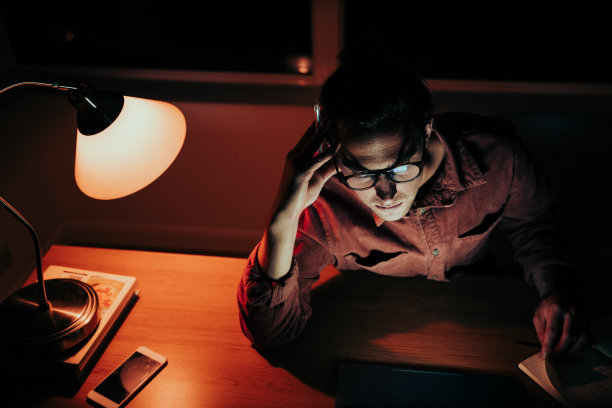 白种男学生疲惫的工作到深夜在电脑上完成作业坐在家里的工作站图片下载