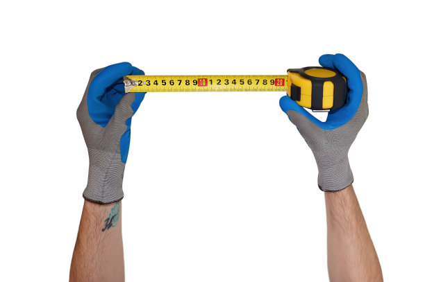 一个男人戴着手套的手拿着一厘米长的卷尺图片下载