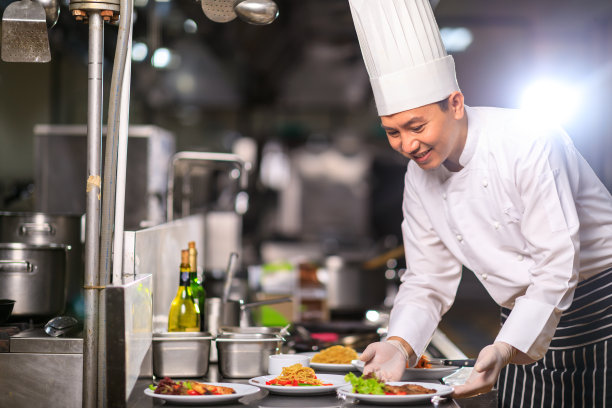 男行政总厨和同事在厨房里讨论菜单。食物和餐厅概念。图片下载