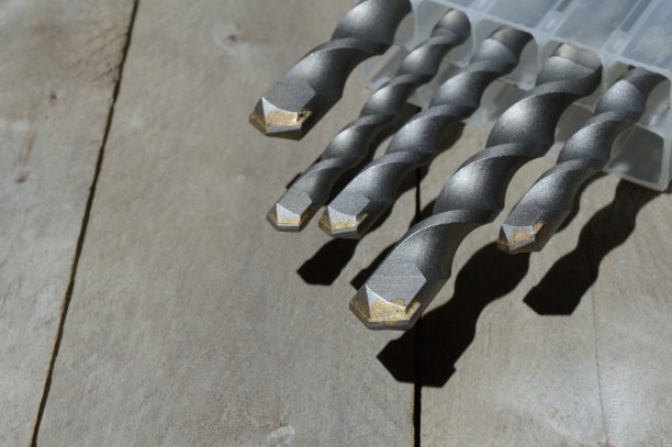 钻头与硬质合金锤钻头躺在一个塑料盒上木板木制背景。特写镜头。图片下载