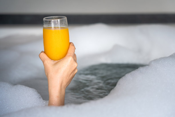 在浴缸里做spa时喝橙汁。图片下载