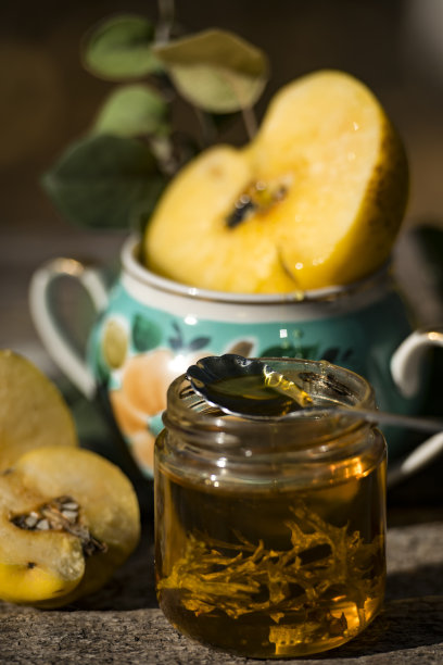 秋天的静物照片成熟的木瓜在奶奶的花瓶附近的蜂蜜图片下载