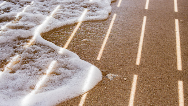 阳光冲破了码头，沙滩上的浪花在嬉戏图片下载