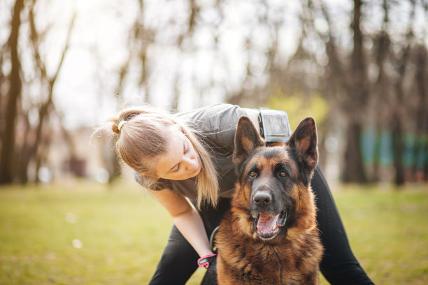 大自然中的年轻女子和德国牧羊犬图片下载
