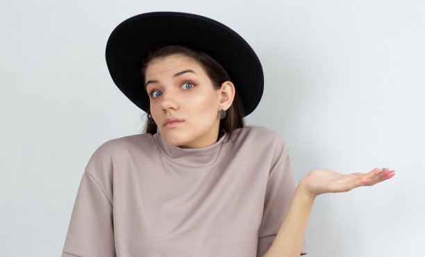 一个年轻女子的肖像耸肩在白色的背景图片下载