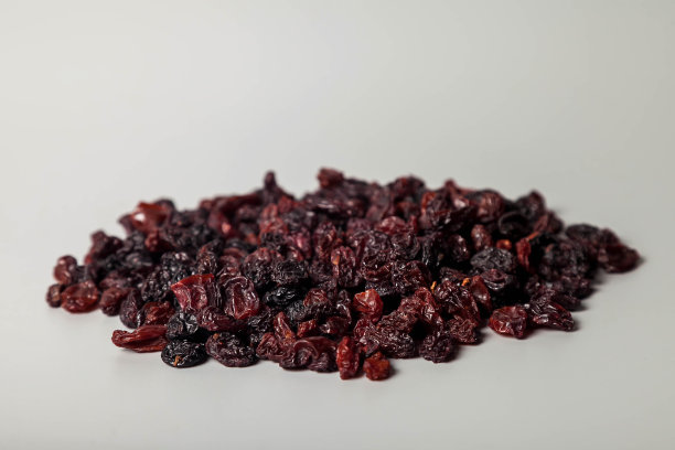 灰色背景上的各种黑色葡萄干图片下载