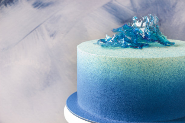 现代蓝色蛋糕与巧克力天鹅绒和益寿糖装饰。图片下载