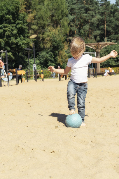 小女孩拿着球在沙滩上图片下载