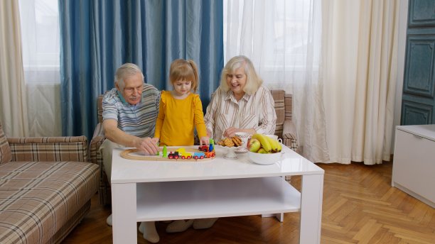 老爷爷奶奶带着小孙子在家里玩游戏，在火车上玩玩具火车图片下载