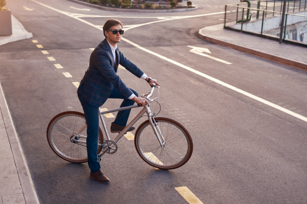现代上班族穿着西装在城市里骑自行车图片下载