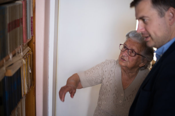 老妇人向儿子展示她的古董图书馆图片下载