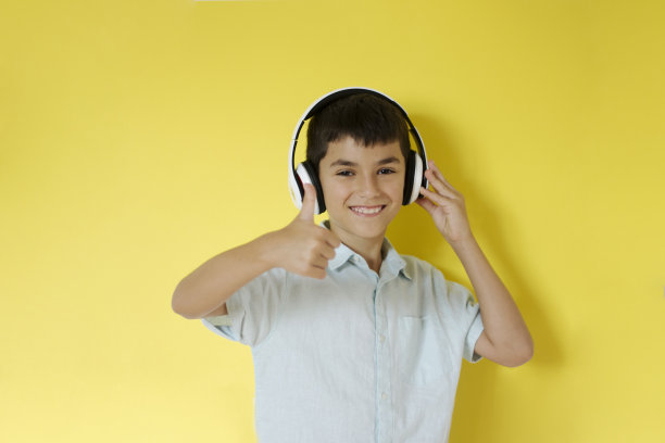 小男孩戴着耳机，竖起大拇指图片下载