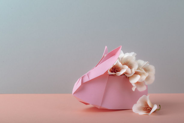 折纸兔子与鲜花和鸡蛋，复活节快乐，节日问候，农业，春节概念。极简主义的风格。空白的空间。图片下载