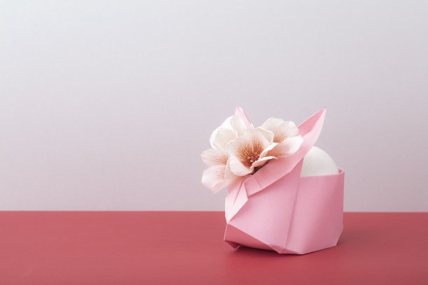 折纸兔子与鲜花和鸡蛋，复活节快乐，节日问候，农业，春节概念。极简主义的风格。空白的空间。图片下载