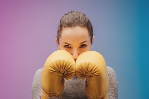 近距离的照片强壮的女运动员在拳击手套拳击手摆姿势。隔离在霓虹灯梯度工作室背景。美丽的白人女人练习图片下载