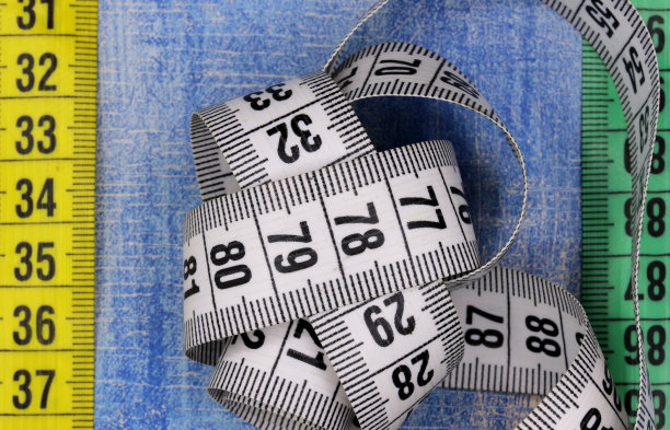 蓝色木制背景上的卷尺图片下载