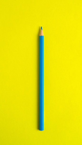 蓝色铅笔，黄色背景特写。图片下载