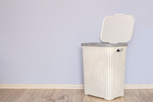 蓝色墙边有一个开放式的洗衣篮，里面放着要洗的衣服图片下载