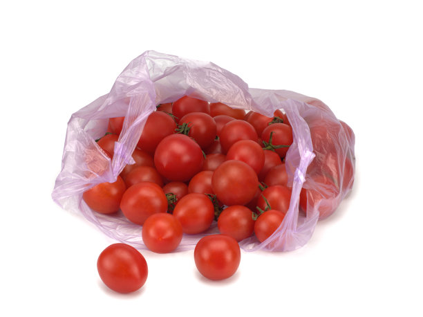 鲜红的西红柿装在一个透明的塑料袋里，背景是白色的图片下载
