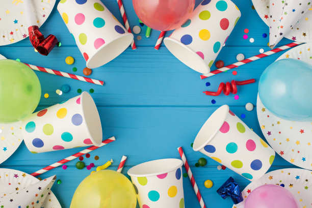 生日聚会组成的俯视图照片螺旋蜡烛管子条纹草帽气球五彩纸屑波尔卡圆点纸杯和盘子在孤立的蓝色木制桌子背景与copyspace图片下载