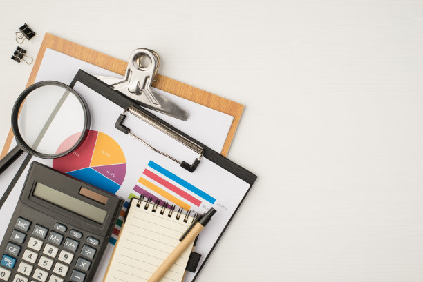 顶视图照片的商业工作场所与两个文件夹饼图，图表，活页夹，放大镜，玻璃，计算器，笔记本和钢笔，在孤立的白色背景与拷贝空间图片下载