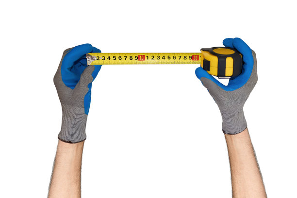 一个男人戴着手套的手拿着一厘米长的卷尺图片下载