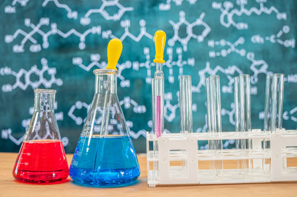 具有黑板背景的各种化学配方的实验室玻璃器皿。图片下载