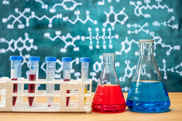 具有黑板背景的各种化学配方的实验室玻璃器皿。图片下载