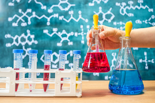 具有黑板背景的各种化学配方的实验室玻璃器皿。图片下载