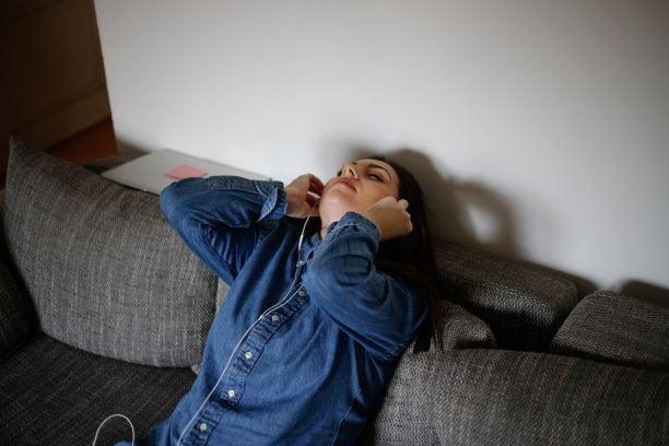 年轻女子在床上听音乐的照片图片下载