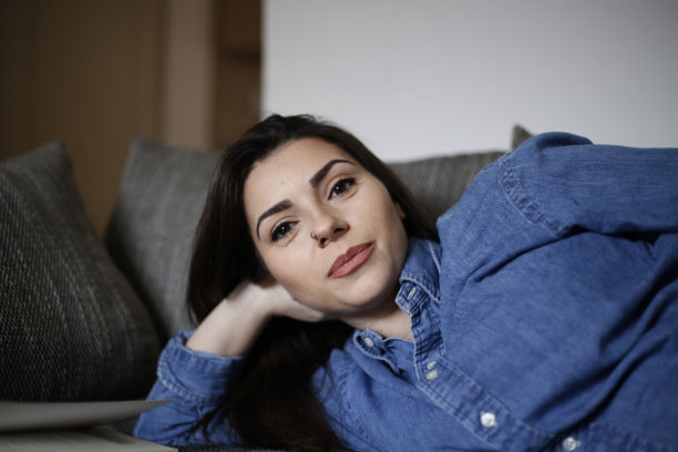 快乐的年轻女子在床上休息。库存图片图片下载