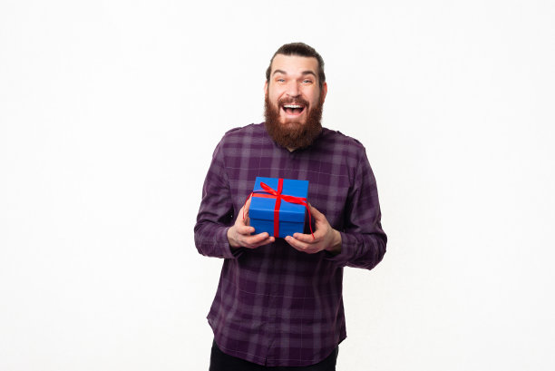 这是一个留着胡子的年轻人拿着蓝色礼盒的照片图片下载