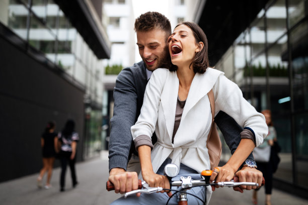 亲密的夫妇有乐趣和骑在城市里的自行车图片下载