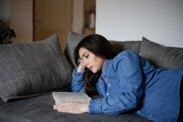 一个女人在隔离期间在家看书。库存图片图片下载