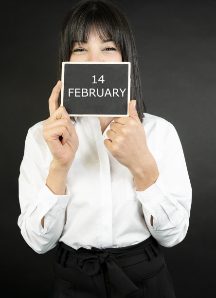 拿着写有2月14日字样的空白黑板的商务女性图片下载