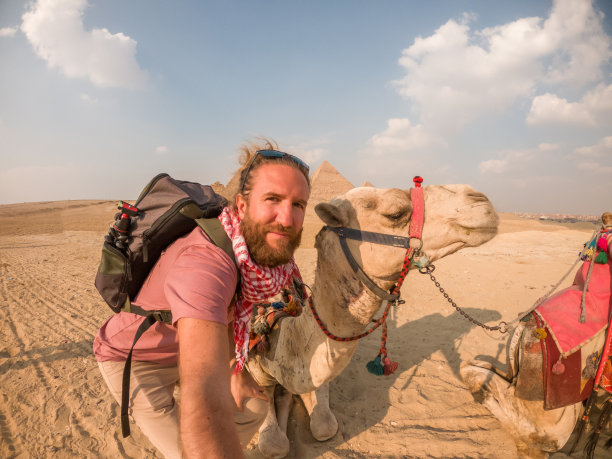 男子在埃及金字塔与骆驼自拍图片下载