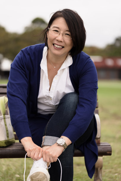 公园长椅上系鞋带的女人图片下载