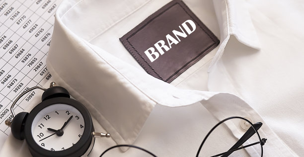 经营理念。印有闹钟和眼镜的衬衫上的品牌文字图片下载