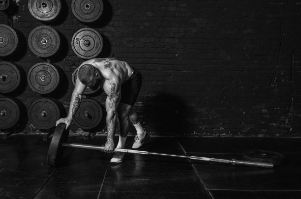 年轻活跃的出汗强壮的肌肉健康的人与大肌肉把沉重的铁重量板上的杠铃为硬核交叉体操举重或硬举锻炼训练真实的人锻炼图片下载