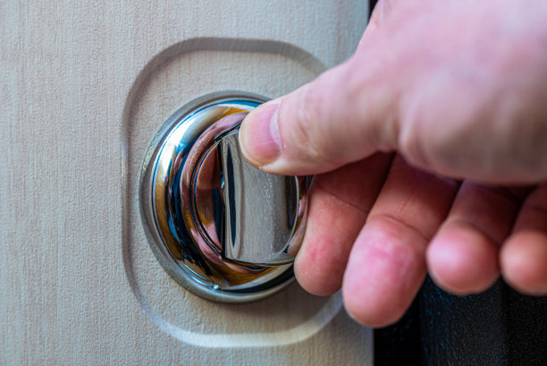 一个人的手在一个圆形门闩上的特写。图片下载