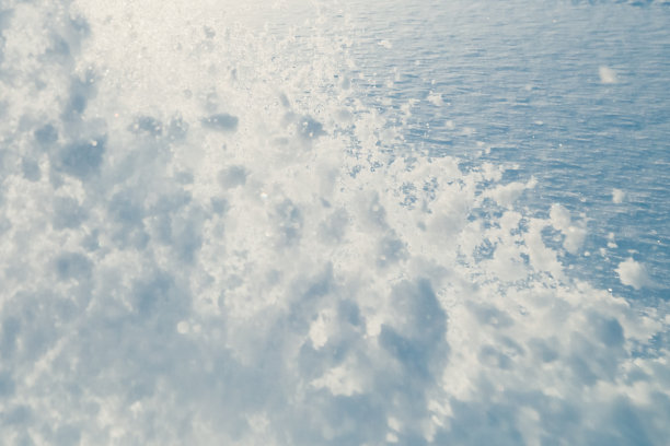 雪花飞溅在空中，蓝天为背景图片下载