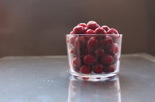 食物照片冷冻樱桃或樱桃在玻璃玻璃餐具在黑色的背景与文字吃一个地方的copyspace图片下载