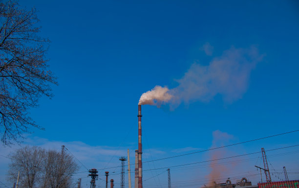 烟雾从化工厂烟囱在多云的天空背景。生态的主题。图片下载