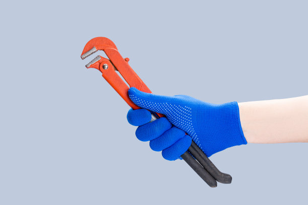 勤杂工修理最小的概念。工人拿着猴扳手工具隔离在灰色背景图片下载