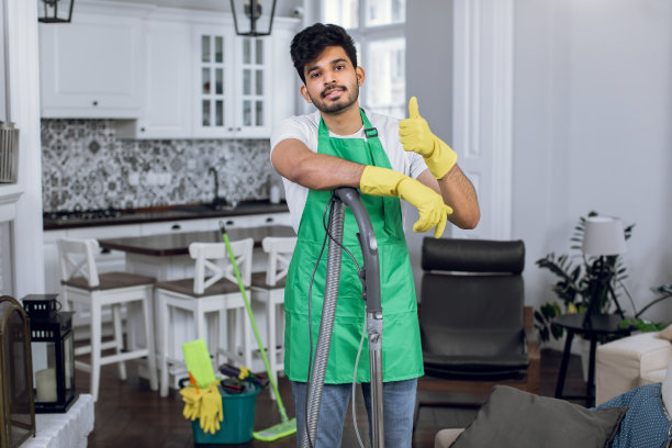 印度男子专业清洁服务人员穿着制服和橡胶手套显示拇指向上图片下载